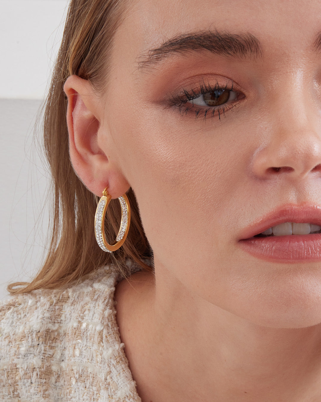 This is the product picture of elegant hoop earrings with micro pavé crystals plated in gold in sterling silver material