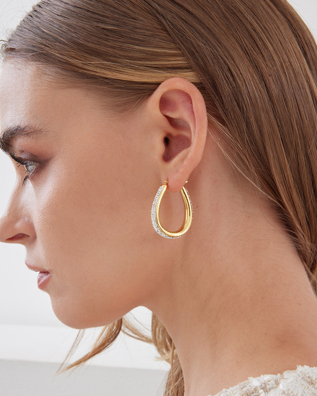 This is the product picture of elegant hoop earrings with micro pavé crystals plated in gold in sterling silver material