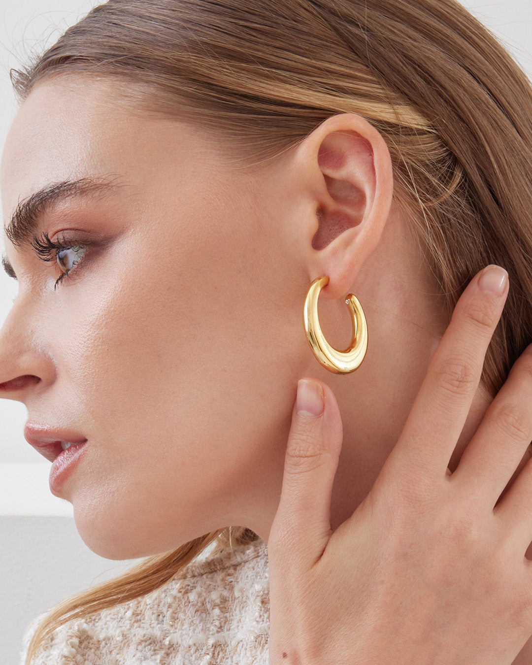 This is the product picture of organic shape elongated style hoop earrings plated in gold in sterling silver material