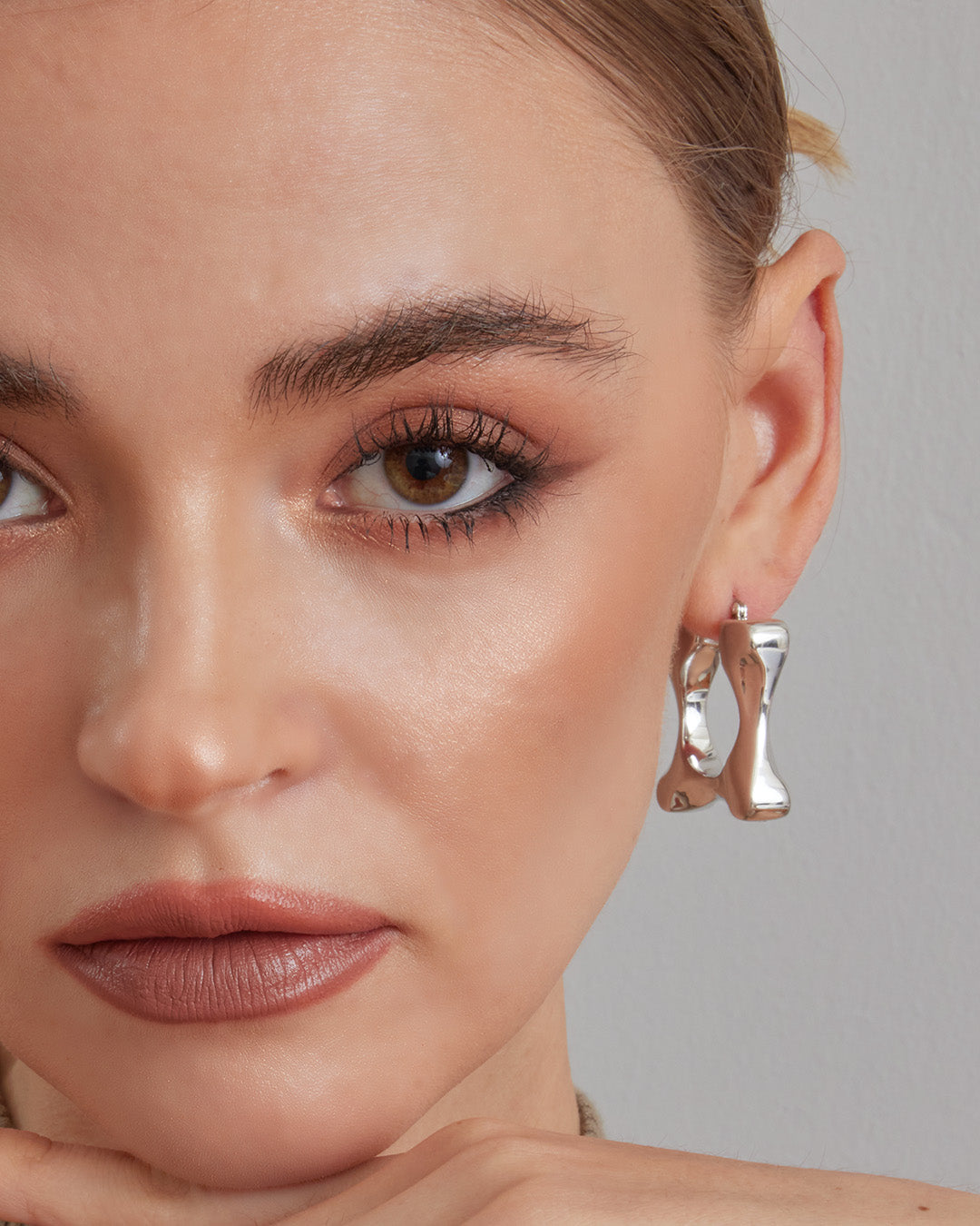 This is the product picture of a chunky style hoop that has a rectangular organic shape earrings plated in white gold in sterling silver material