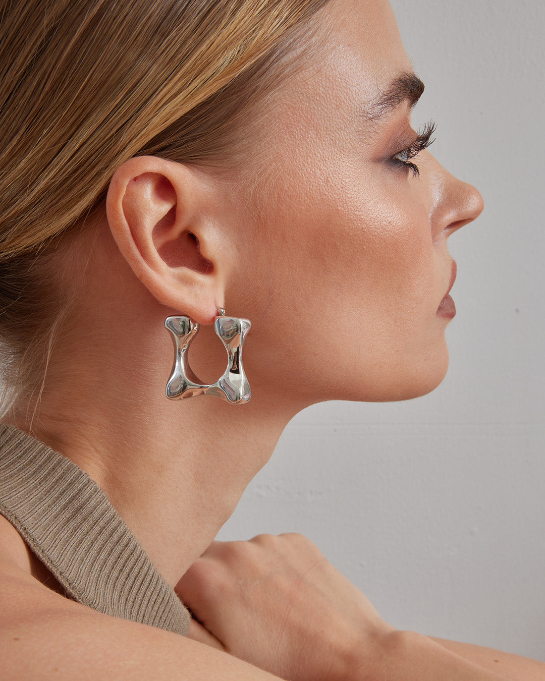 This is the product picture of a chunky style hoop that has a rectangular organic shape earrings plated in white gold in sterling silver material