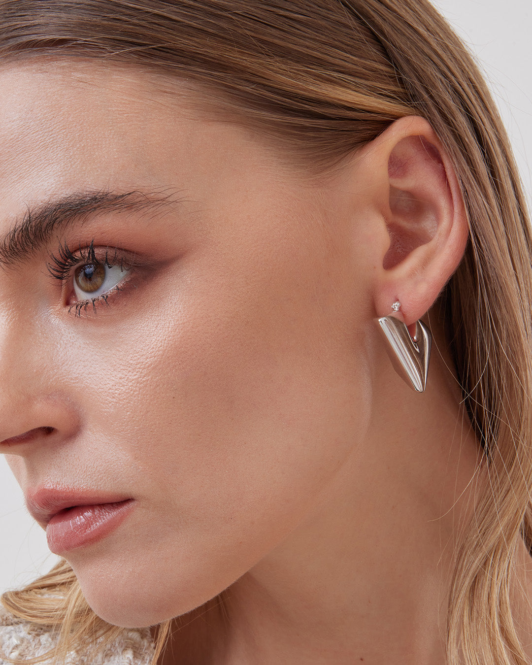 This is the product picture of chunky triangle diamond shape hoop earrings plated in white gold in sterling silver material