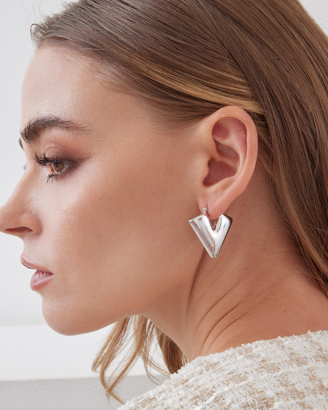 This is the product picture of chunky triangle diamond shape hoop earrings plated in white gold in sterling silver material