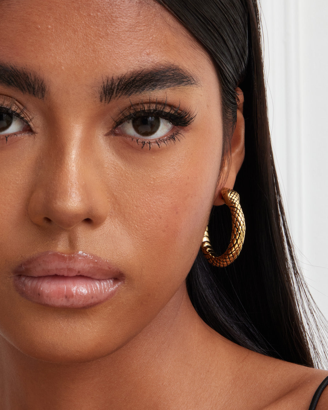 This is the product picture of a snake design hoop earrings plated in gold in sterling silver material