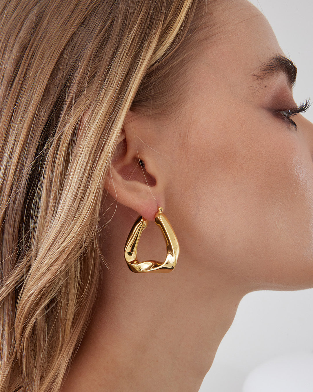 This is the product picture of a triangular twisted chunky hoop earrings plated in gold in sterling silver material