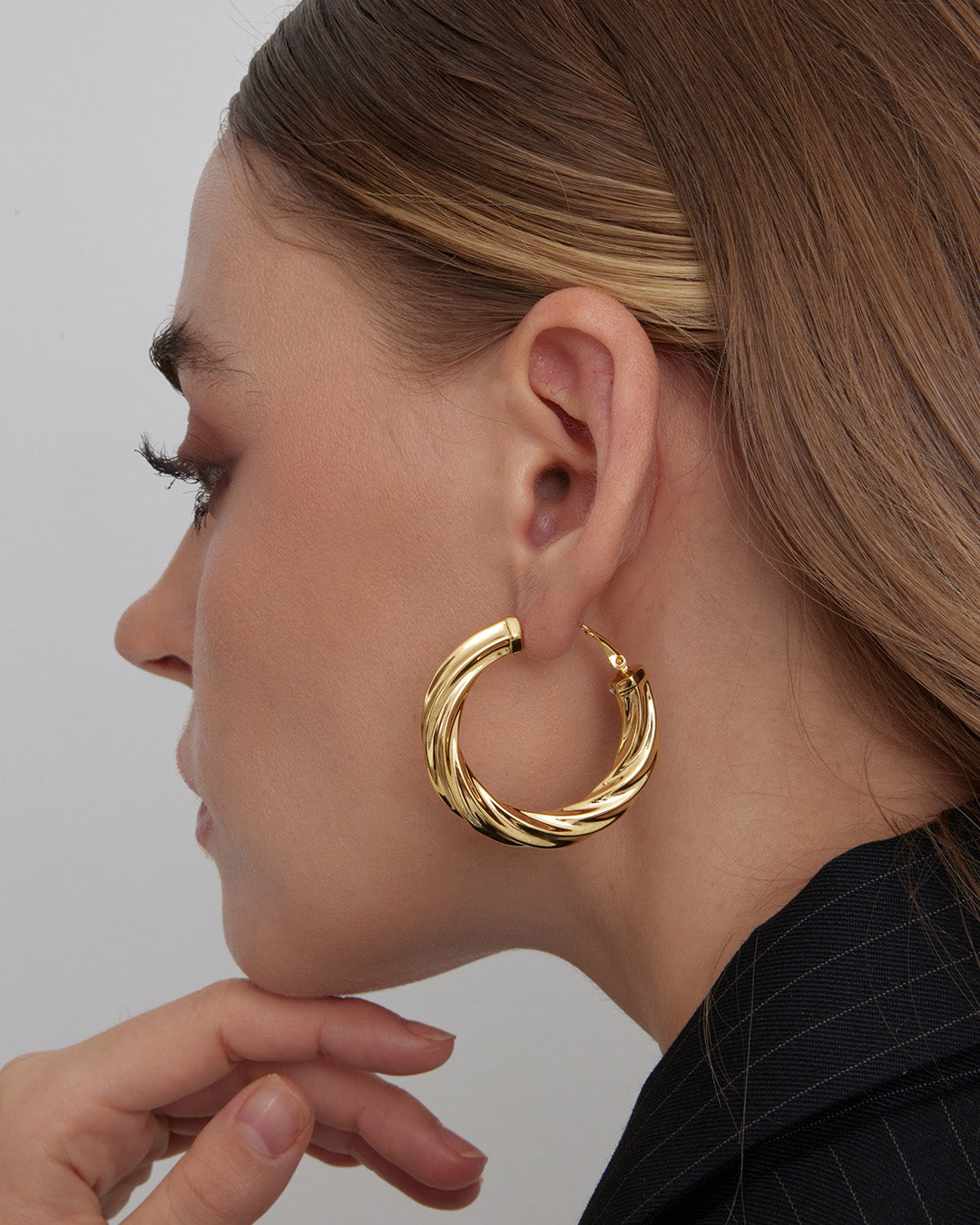 This is the product picture of luxury freeform twisted round shape hoop earrings plated in gold in sterling silver material