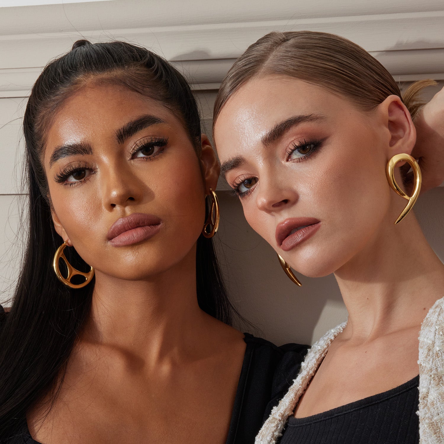2 models side by side wearing oversized hoop earrings and earrings in 18K gold plated over sterling silver