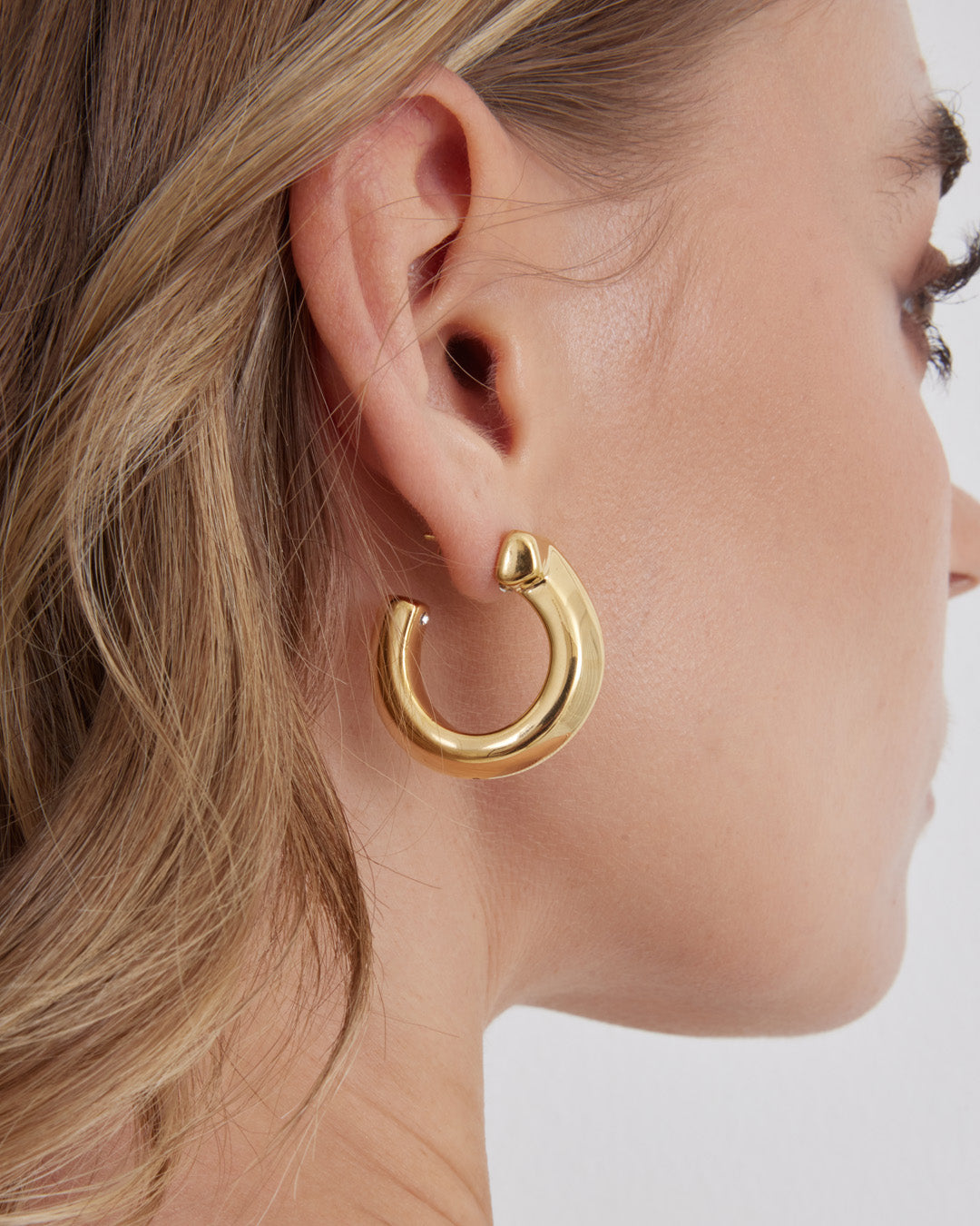 This is the product picture of chunky style hoop earrings plated in gold in sterling silver material