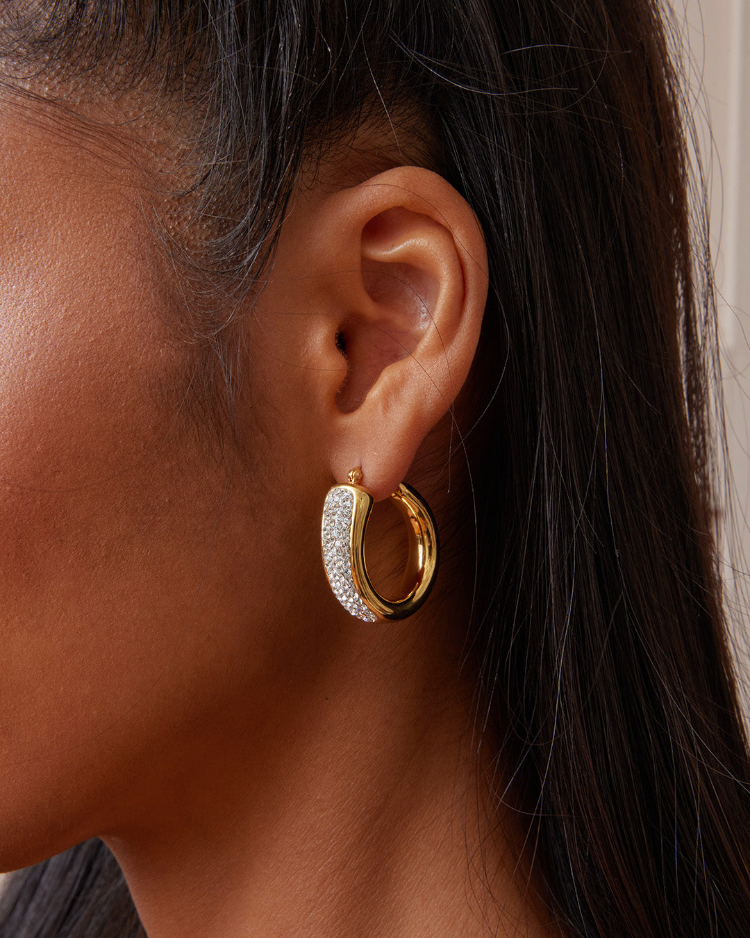 This is the product picture of a chunky statement elegant hoop earrings with micro pavé crystals plated in gold in sterling silver material