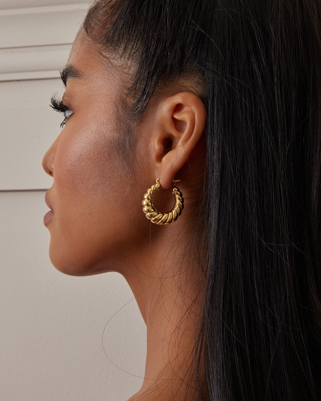 This is the product picture of classic twisted hoop earrings plated in gold in sterling silver material