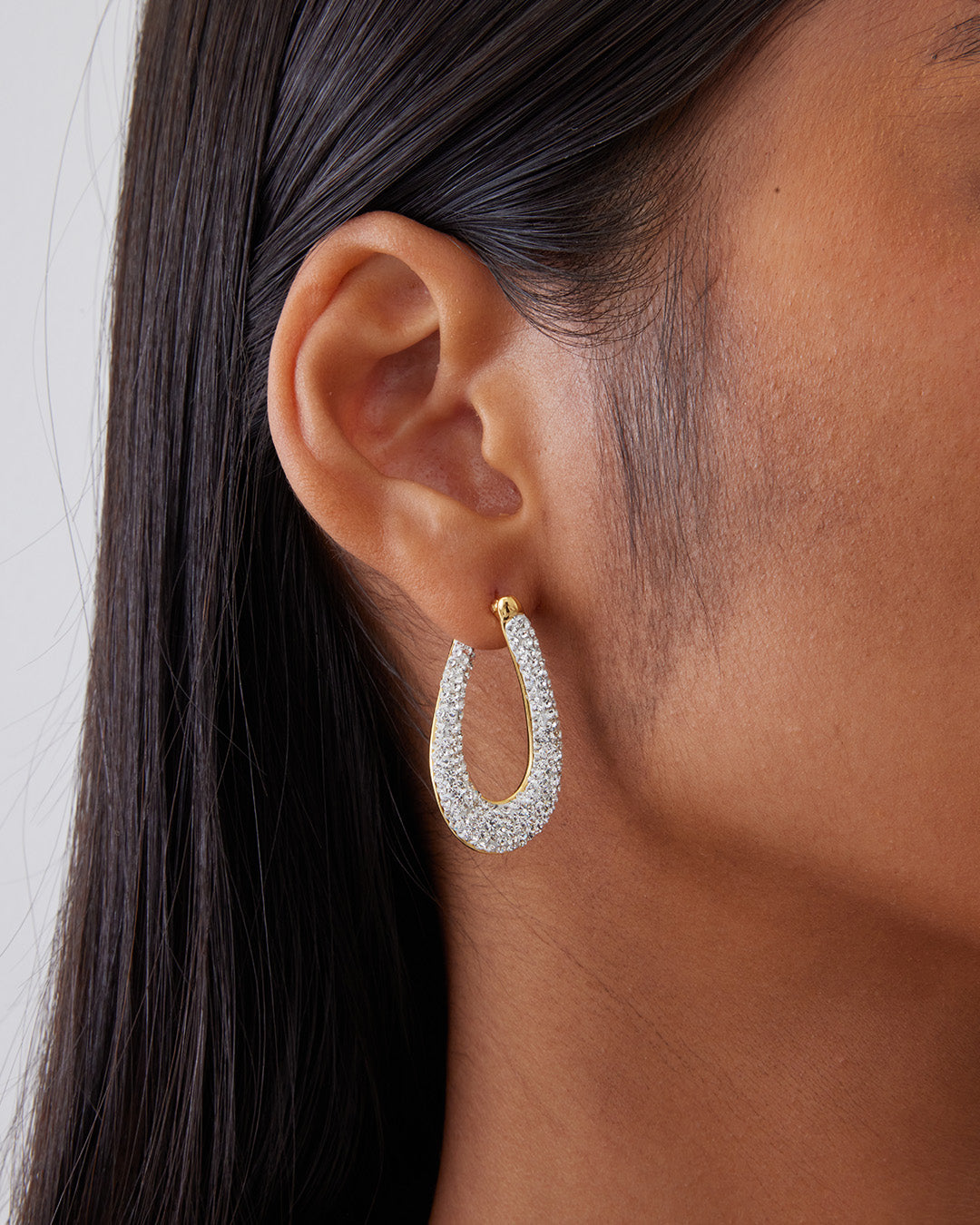 This is the product picture of elegant hoop earrings with micro pavé crystals plated in gold in sterling silver material