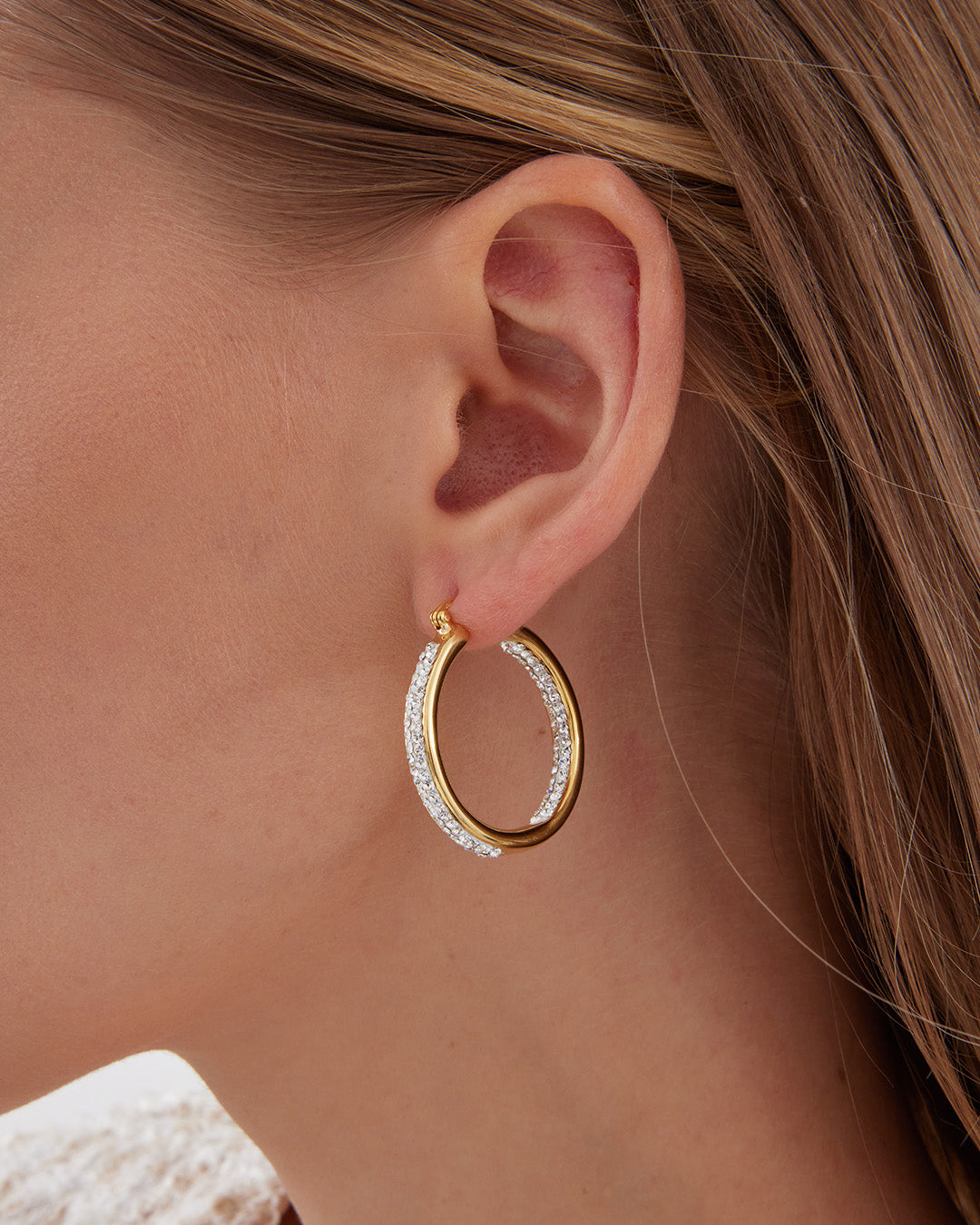 This is the product picture of elegant hoop earrings with micro pavé crystals plated in gold in sterling silver material