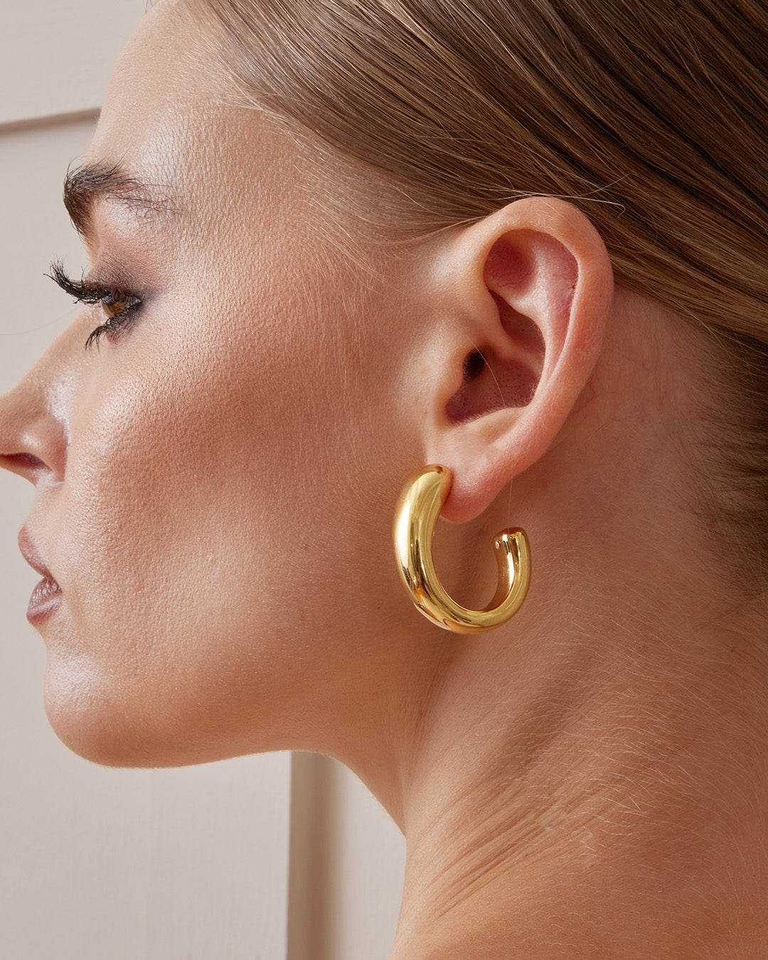 This is the product picture of chunky hoop earrings plated in gold in sterling silver material