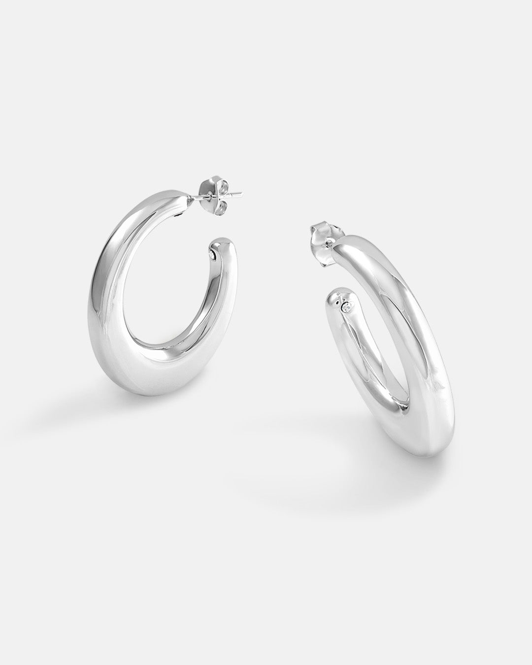 This is the product picture of organic shape elongated style hoop earrings plated in white gold in sterling silver material