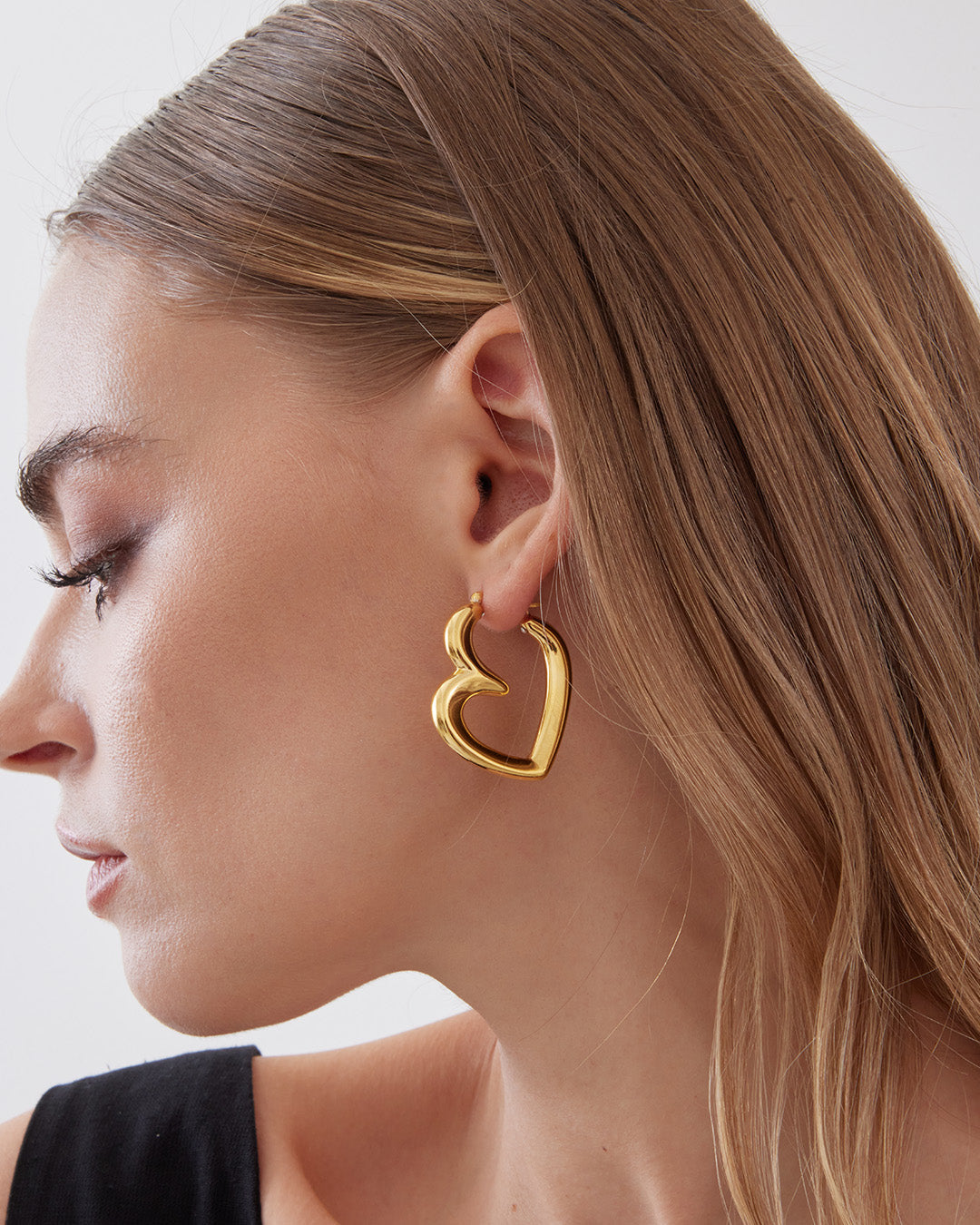 This is the product picture of a freeform design hoop earrings plated in gold in sterling silver material