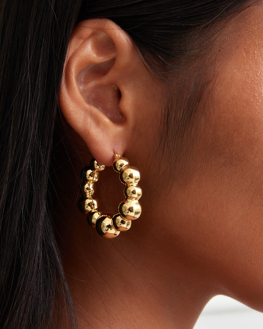 This is the product picture of a chunky style hoop that has a uneven organic bubbles shape earrings plated in gold in sterling silver material