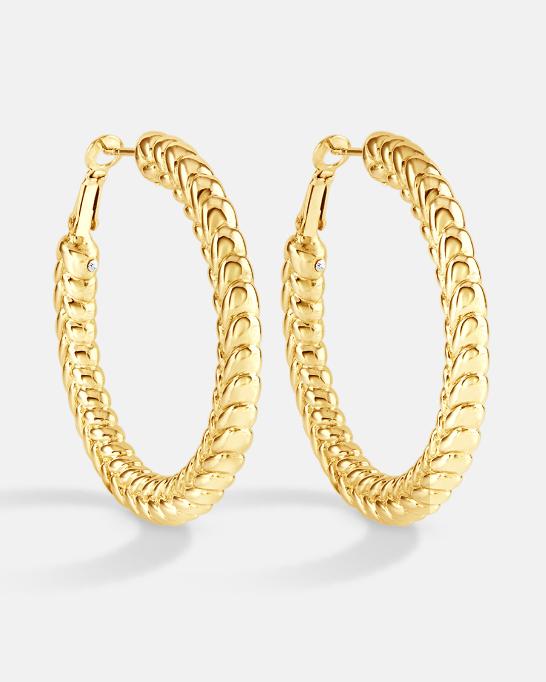 This is the product picture of flat tree leaves design hoop earrings plated in gold in sterling silver material