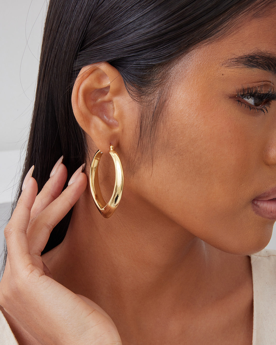 This is the product picture of oversized tear drop shape design hoop earrings plated in gold in sterling silver material