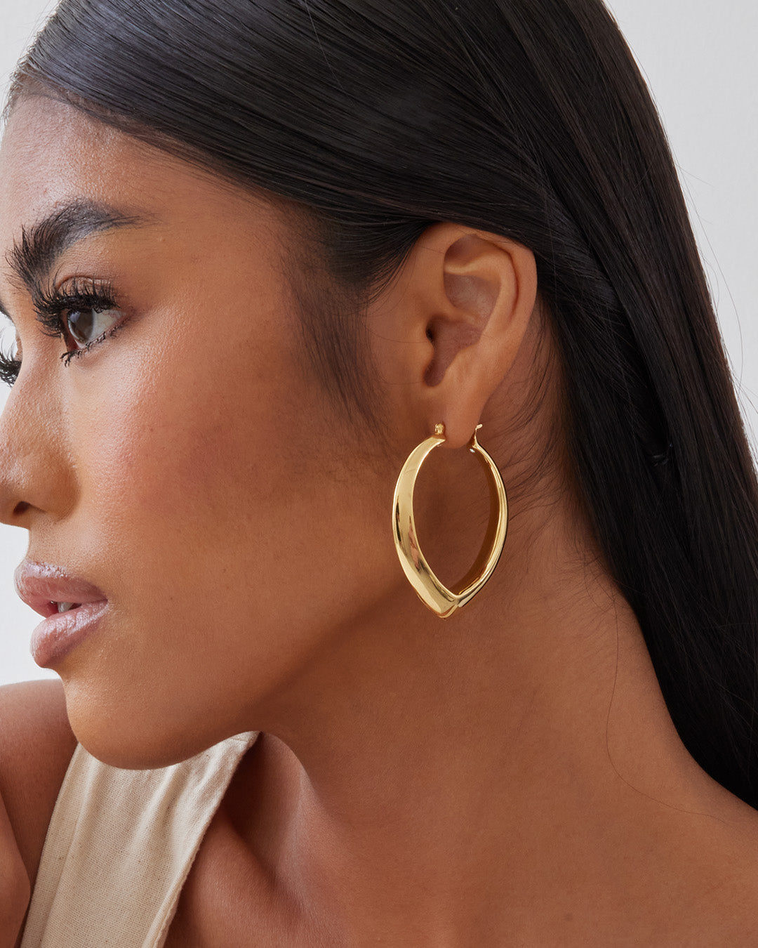 This is the product picture of oversized tear drop shape design hoop earrings plated in gold in sterling silver material