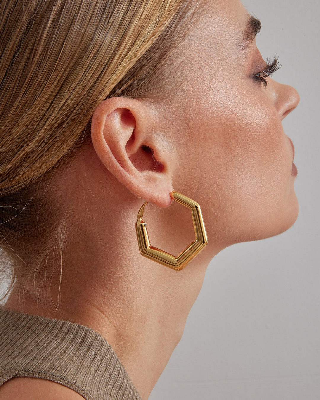 This is the product picture of a minimal hexagon design hoop earrings plated in gold in sterling silver material