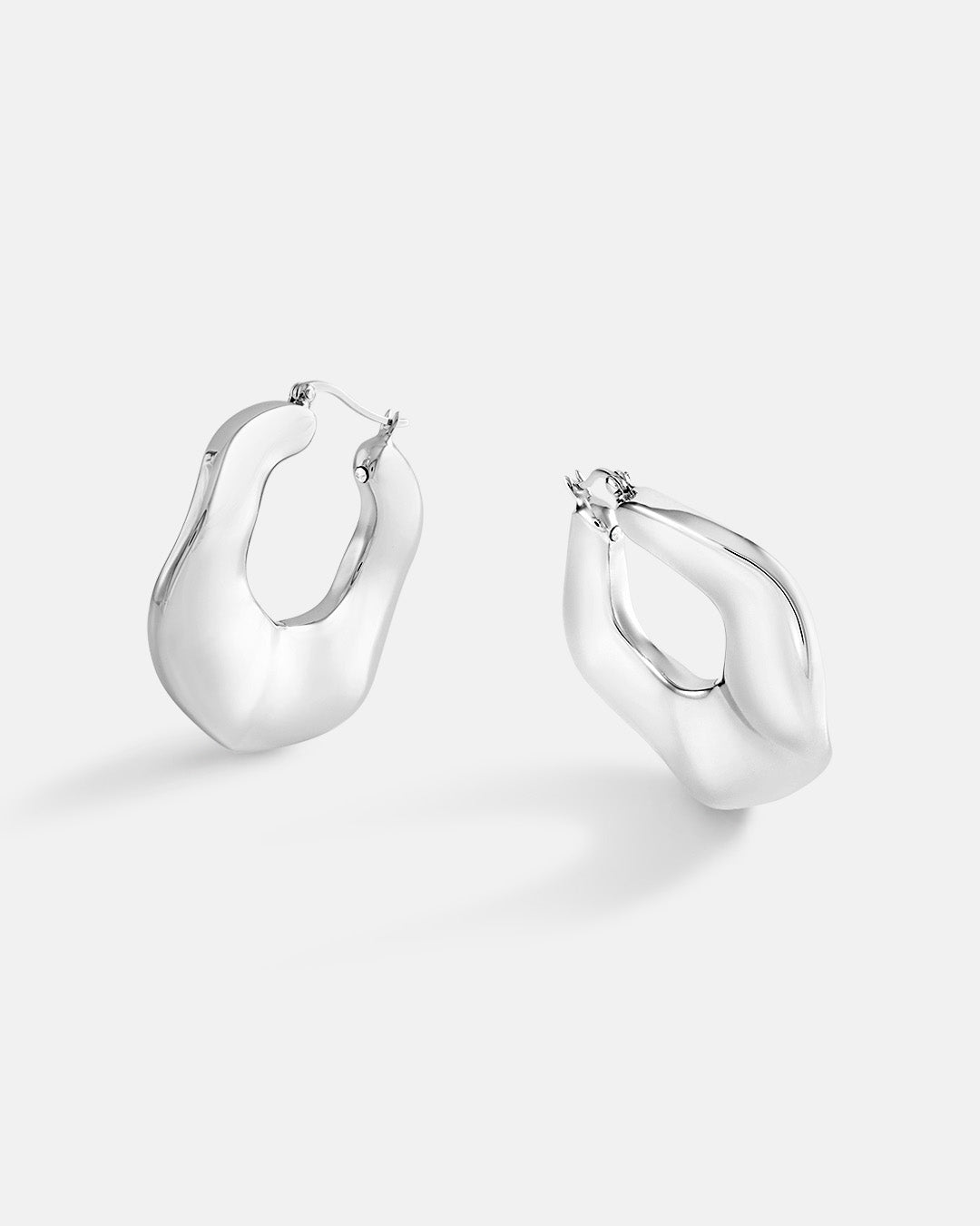 This is the product picture of organic round shape hoop earrings plated in white gold in sterling silver material