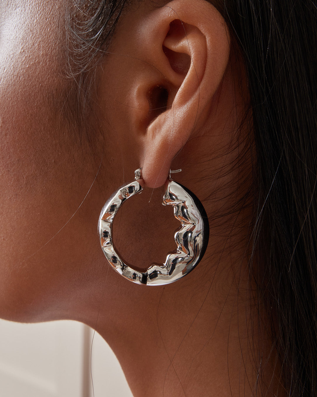 This is the product picture of freeform organic round shape hoop earrings plated in white gold in sterling silver material