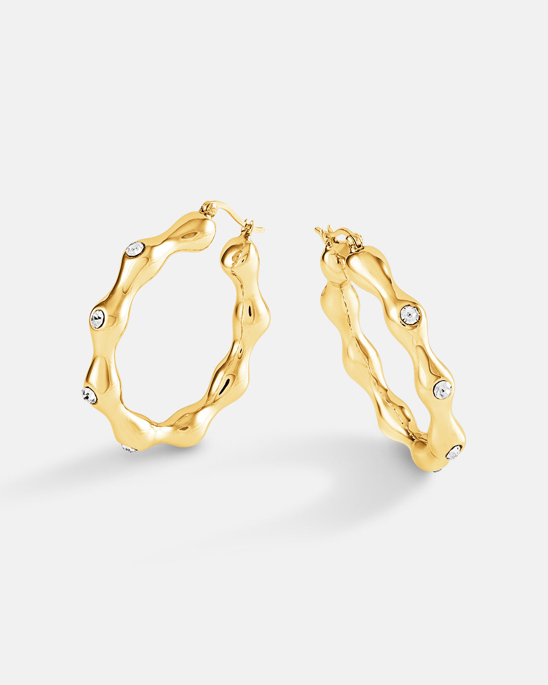 This is the product picture of elegant hoop earrings with accented crystals plated in gold in sterling silver material