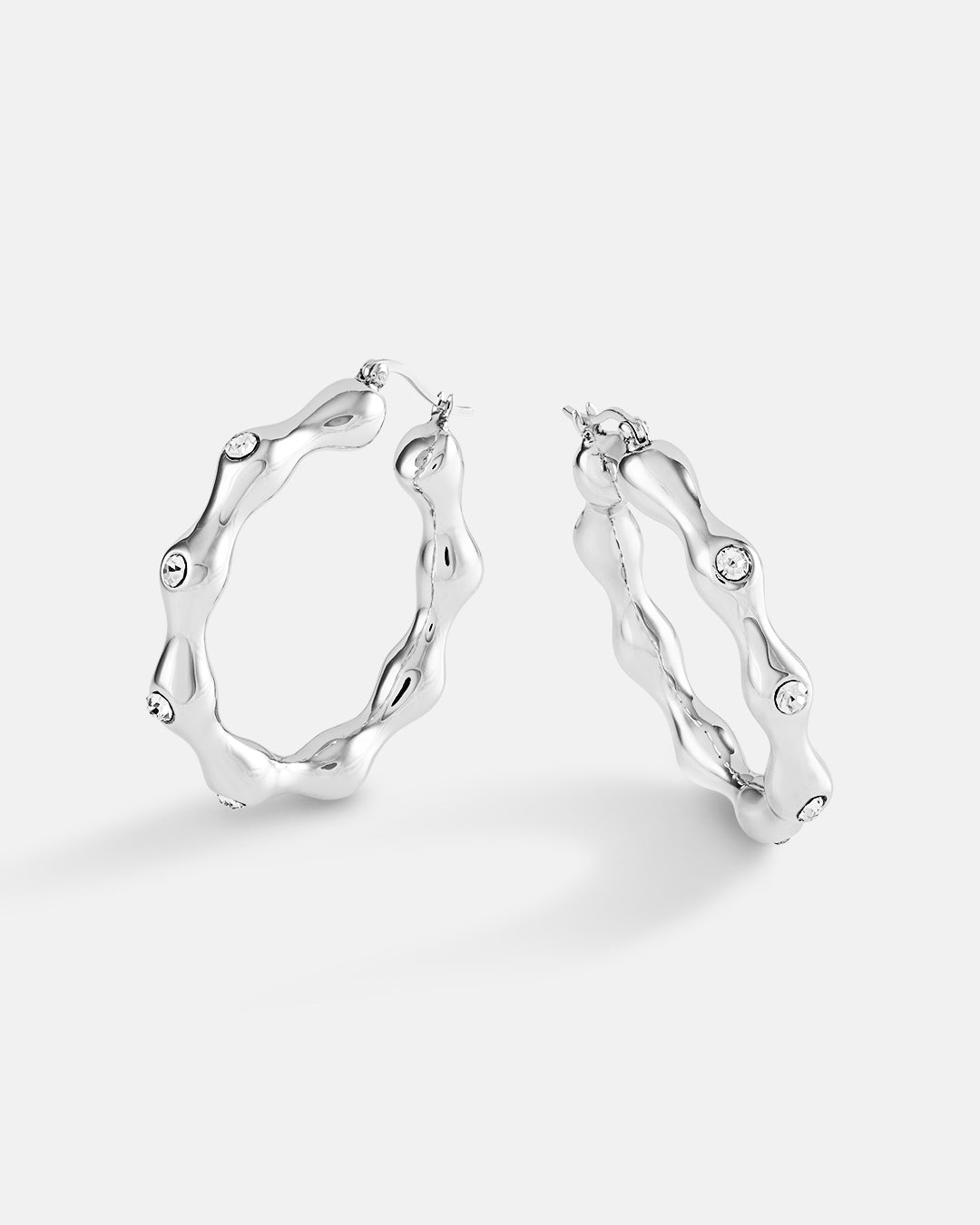 This is the product picture of elegant hoop earrings with accented crystals plated in white gold in sterling silver material