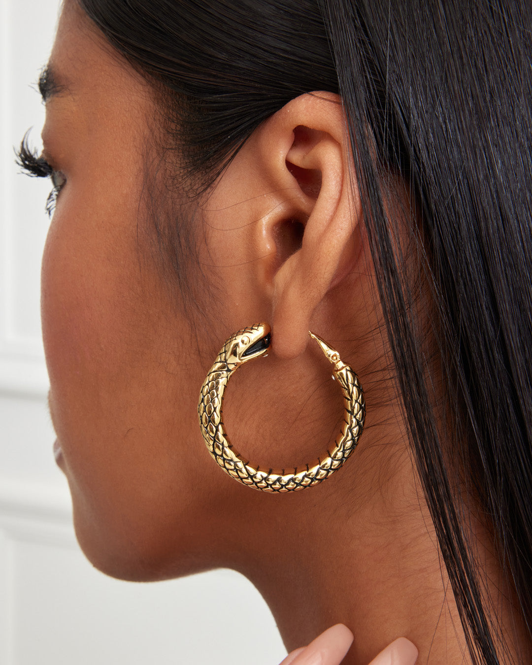 This is the product picture of a snake design hoop earrings plated in gold in sterling silver material