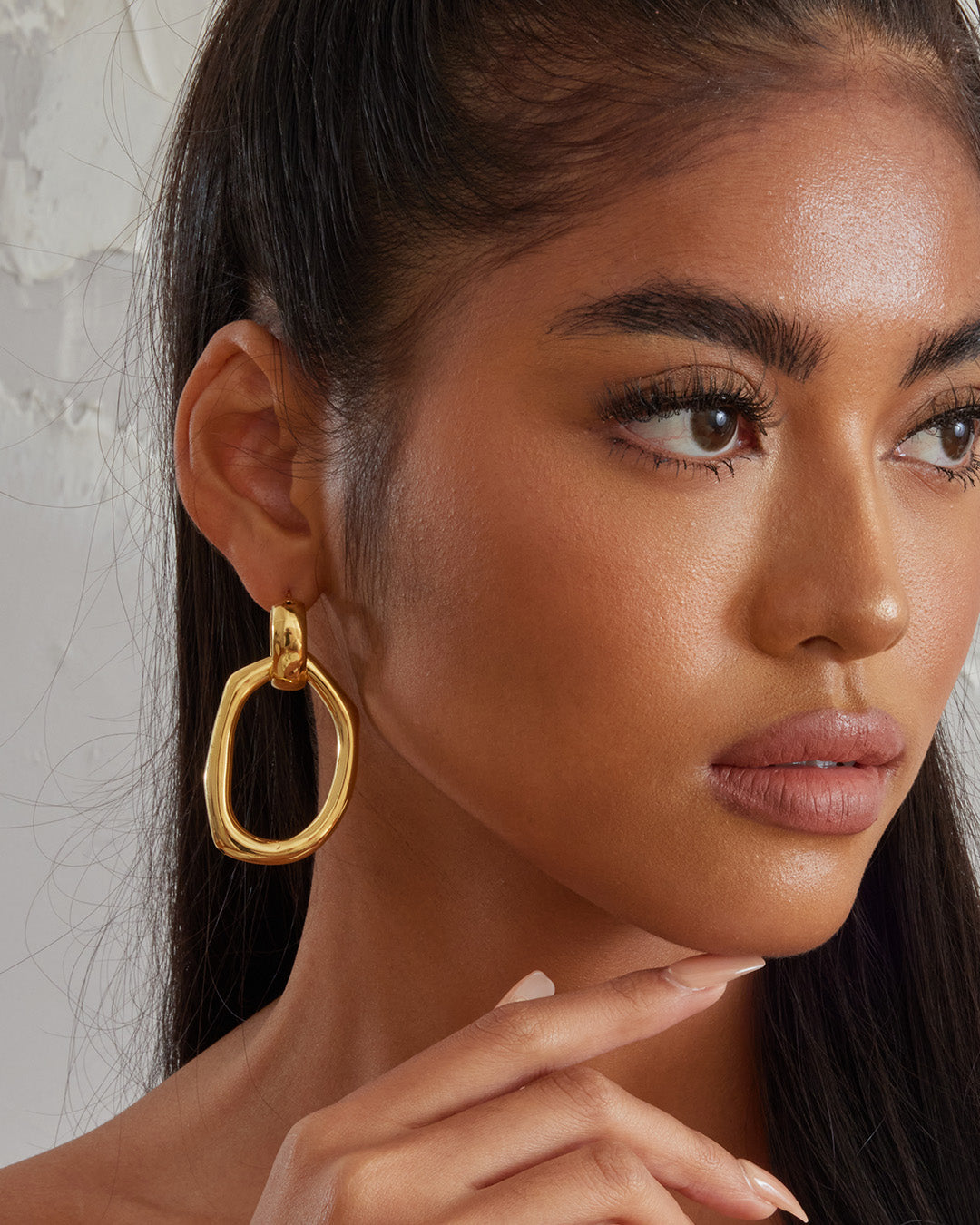 This is the product picture of a oversized drop-down dangle with a freeform shape earrings plated in gold in sterling silver material