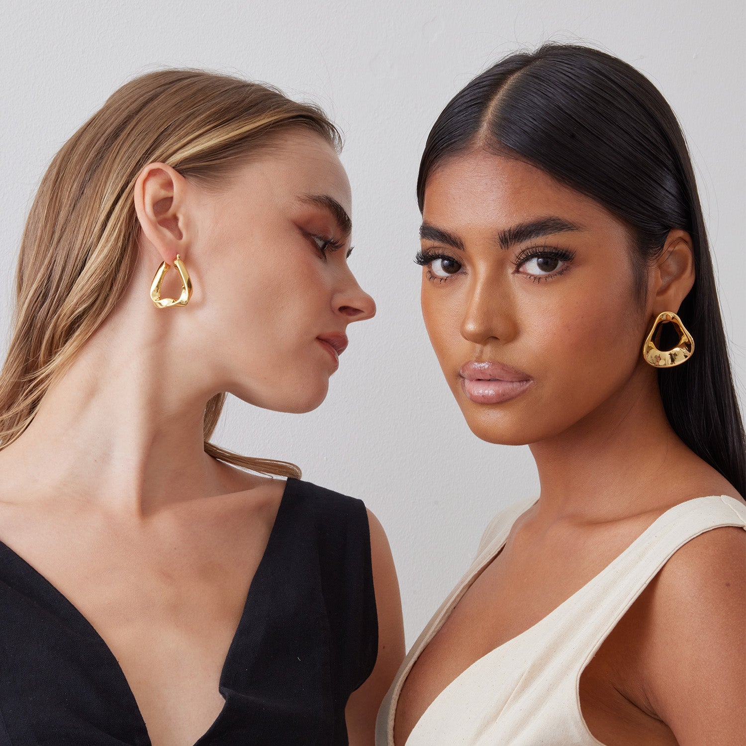 2 models wearing beautiful hoops twisted in sterling silver plated over 18K gold