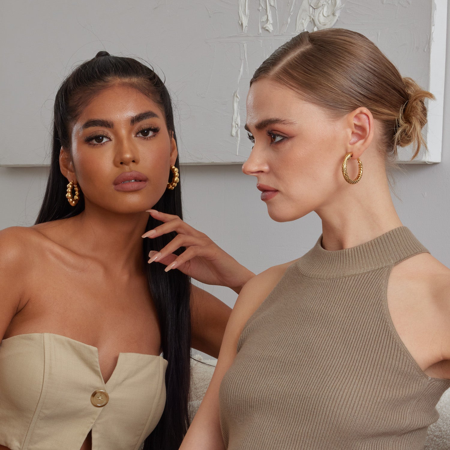 2 models wearing beautiful chunky style hoop earrings 18K gold plated over sterling silver